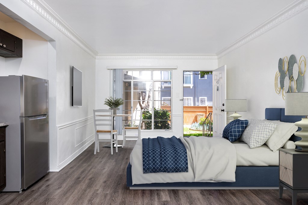 a bedroom with a bed and a refrigerator and a window