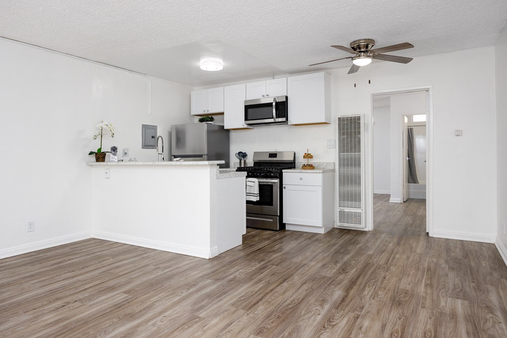 an open kitchen and living room with a ceiling fan