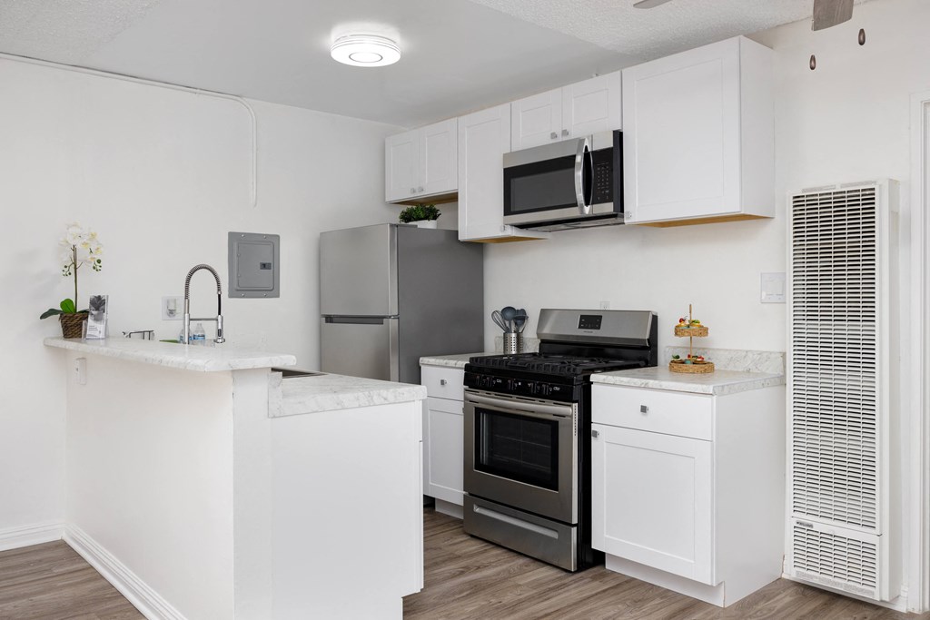 a kitchen with white cabinets and stainless steel appliances