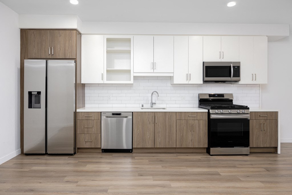a modern kitchen with white cabinets and stainless steel appliances