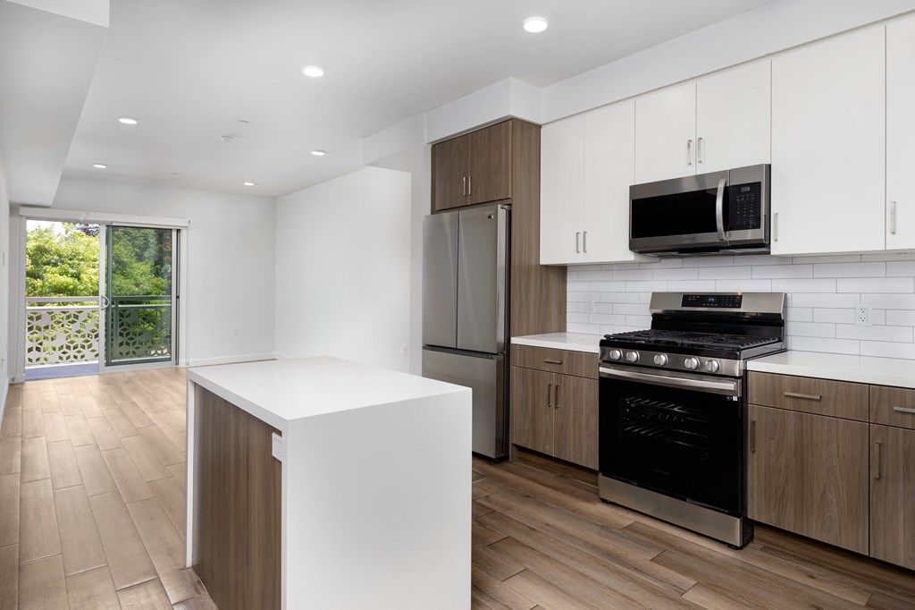 a kitchen with white cabinets and stainless steel appliances and a window