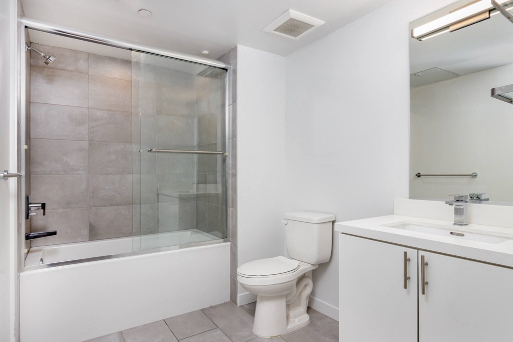 a white bathroom with a shower toilet and sink