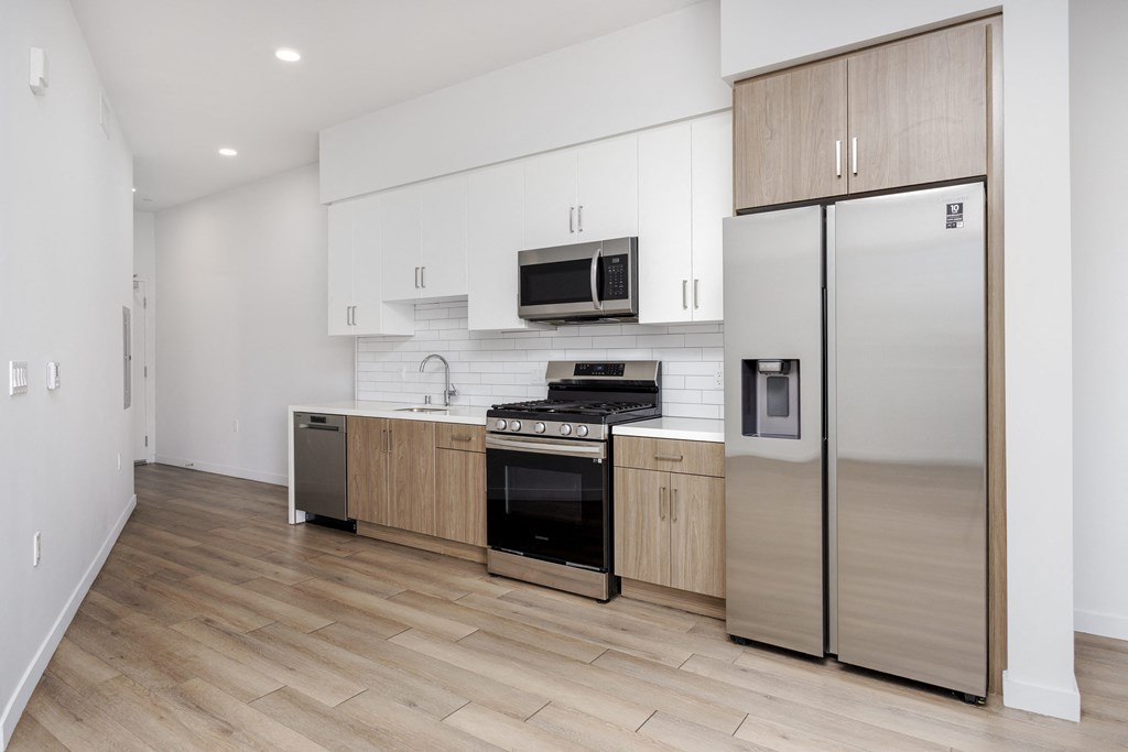 a large kitchen with white cabinets and stainless steel appliances