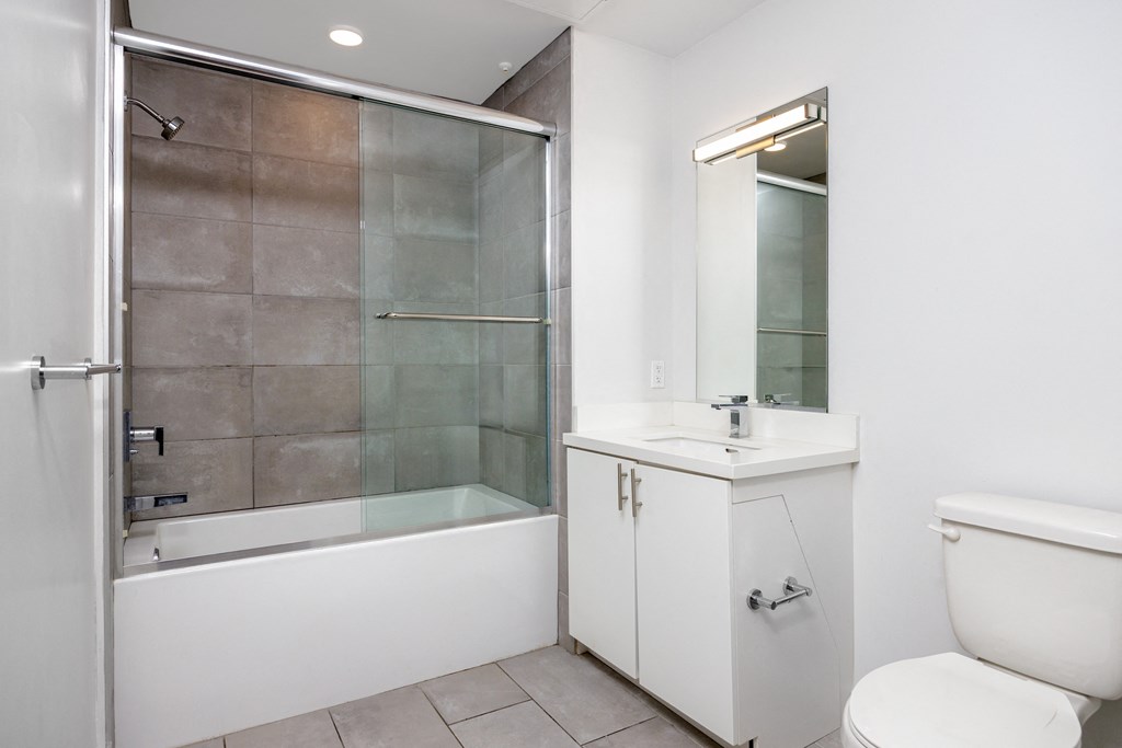 a bathroom with a shower and a sink and a toilet