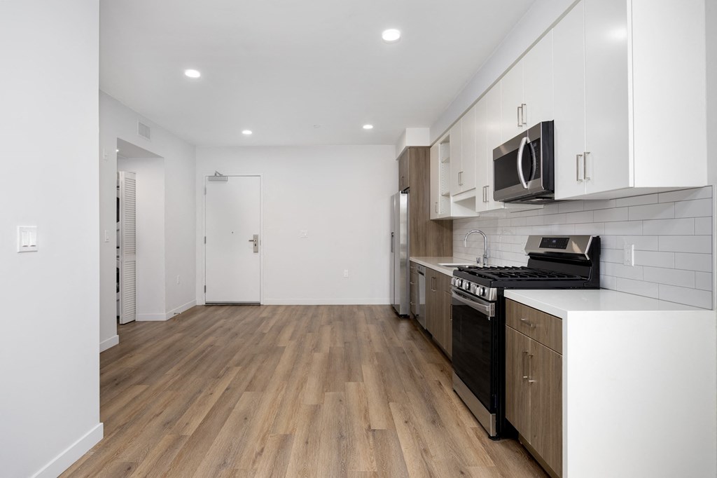 a kitchen with white cabinets and a stove and a microwave