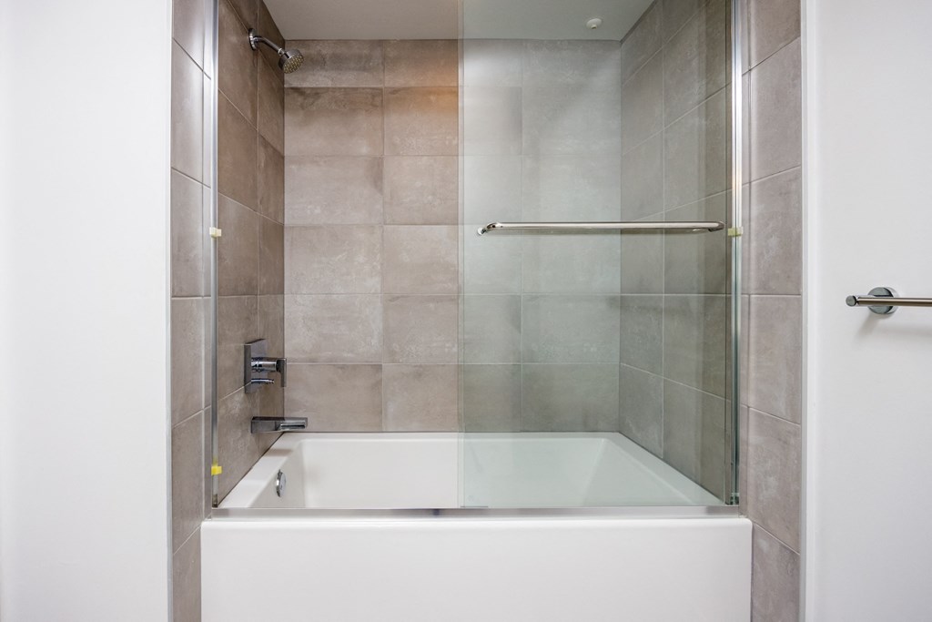 a shower and a bath tub in a tiled bathroom