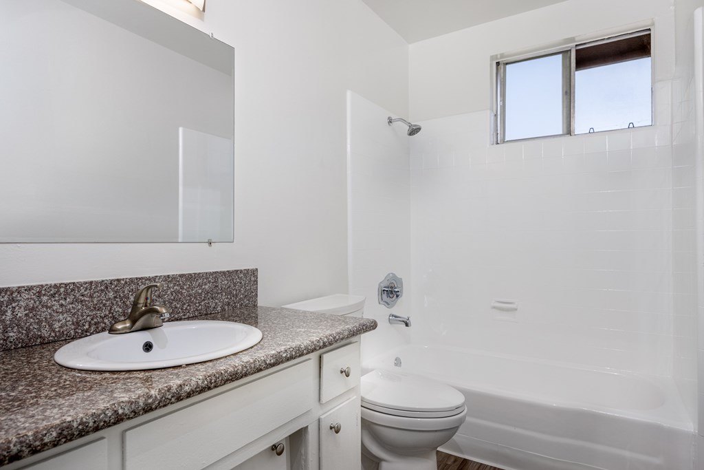 A bathroom with a sink, toilet, and bathtub.