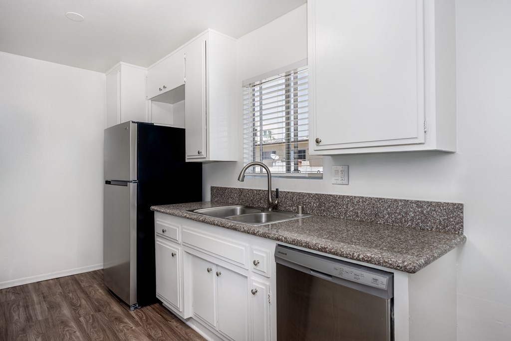 A kitchen with white cabinets and a granite countertop.
