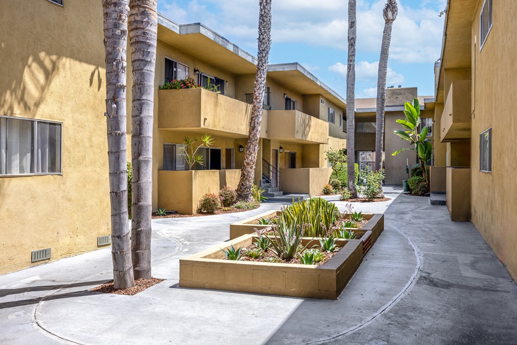 A row of apartment buildings with a planter in the foreground.