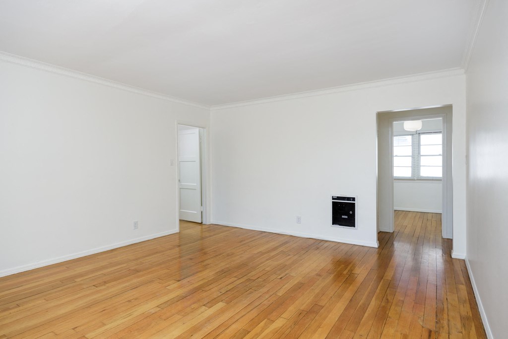 a living room with white walls and a hard wood floor