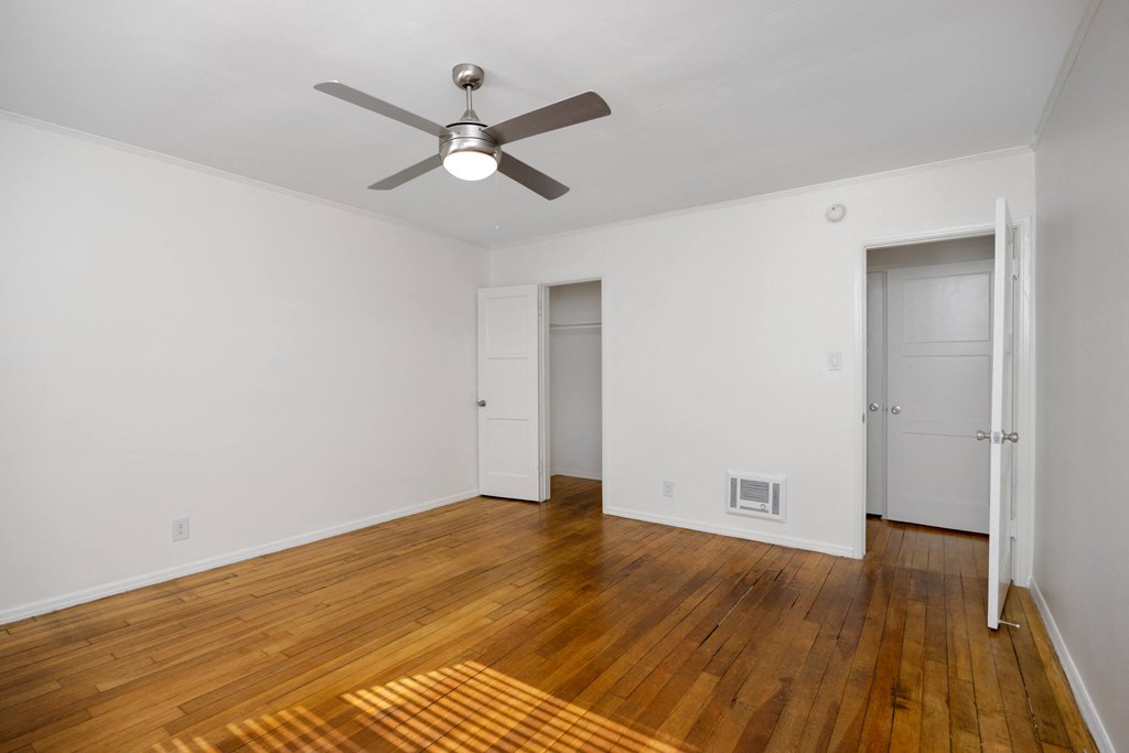 a living room with wood floors and a ceiling fan