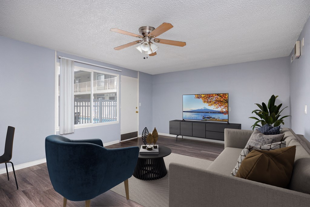A living room with a blue chair and a grey couch.