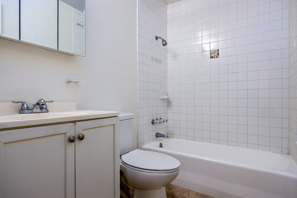 A white bathroom with a toilet, sink, and bathtub.