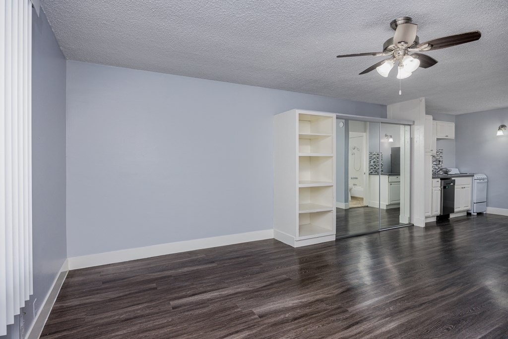 A room with a ceiling fan and a cabinet.