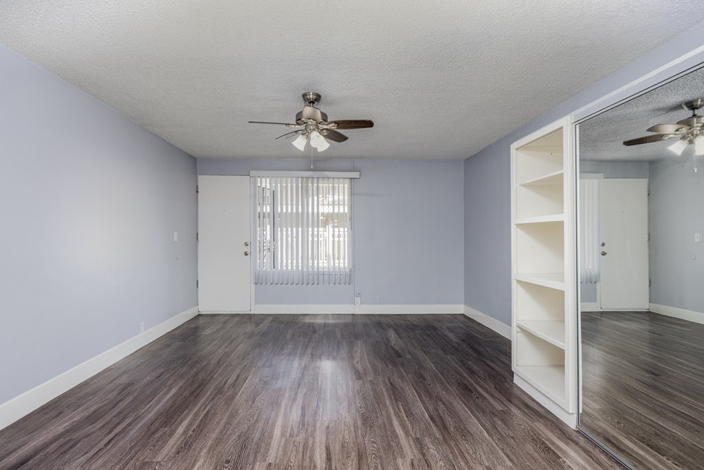 A room with a ceiling fan and a sliding door.
