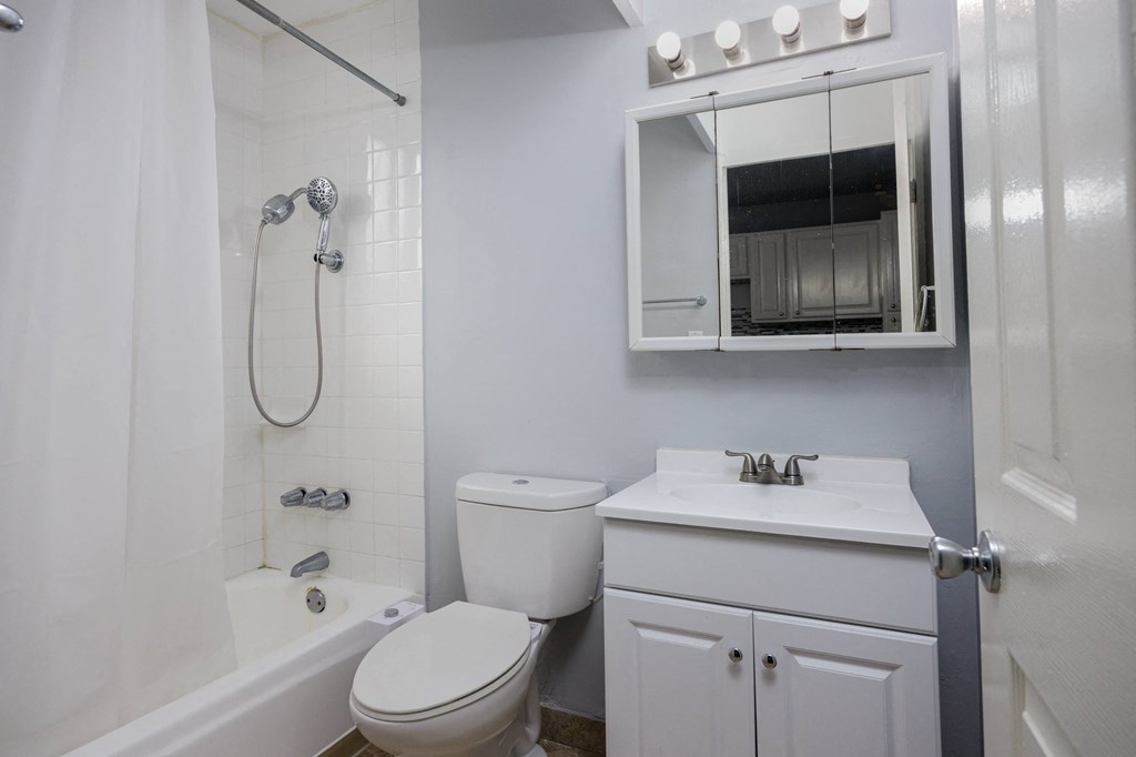 A white toilet and sink in a bathroom.