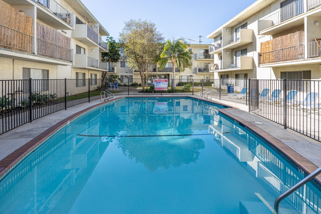 the swimming pool of an apartment building with a blue pool