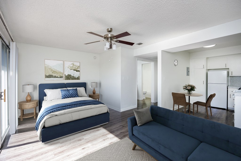 A bedroom with a large bed and a living room with a couch.