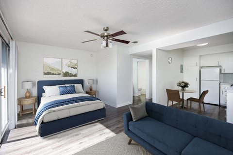 A bedroom with a large bed and a living room with a couch.