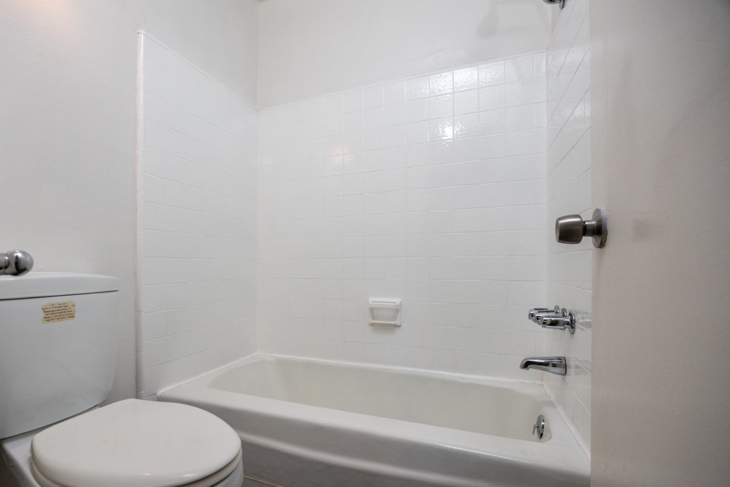 a white bathroom with a tub and a toilet