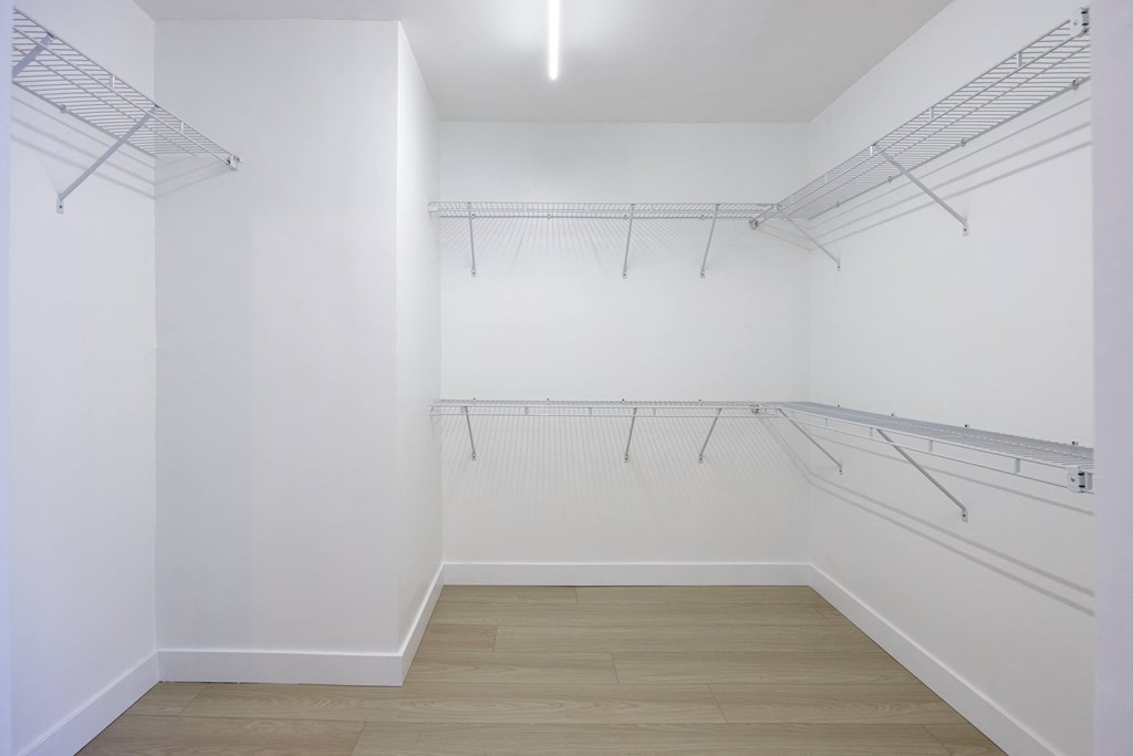 a room with white walls and white racks on the wall and a wood floor