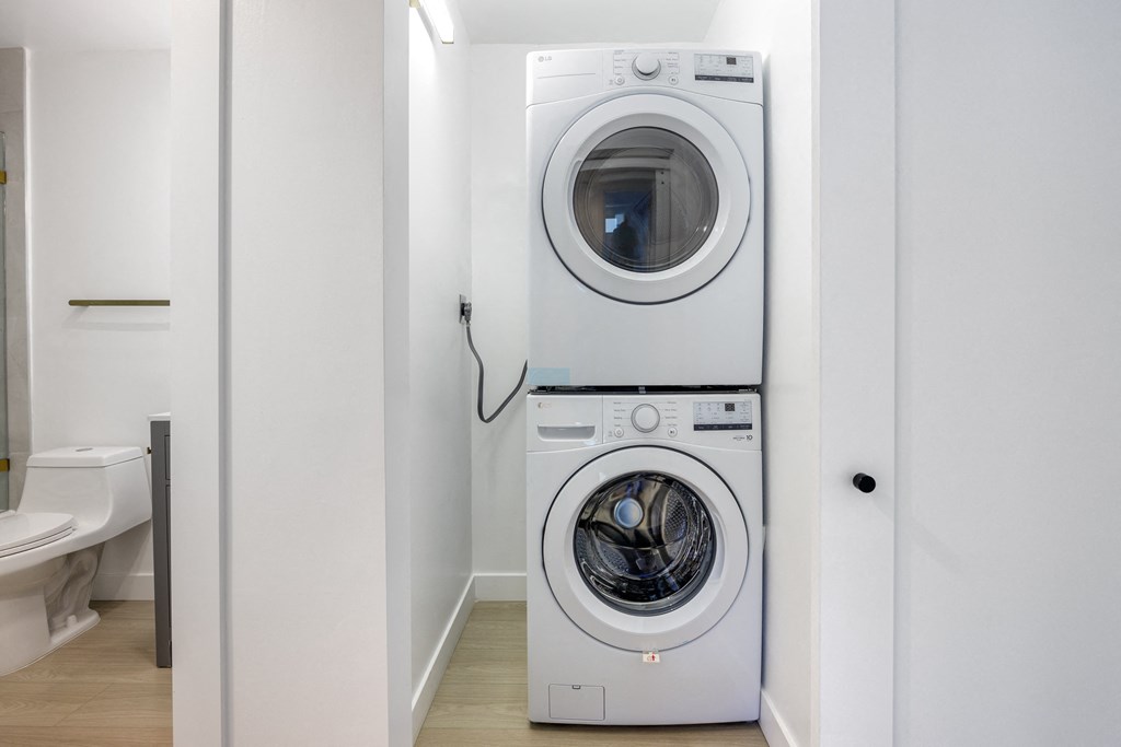 a white washer and dryer in a white laundry room