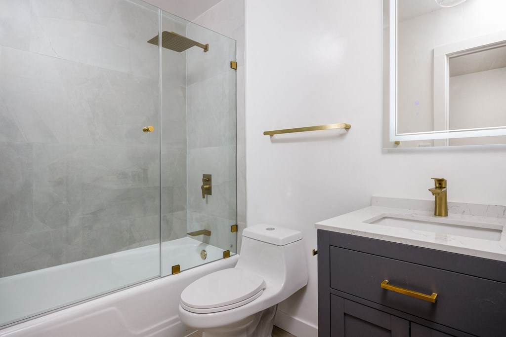 a bathroom with a toilet and a shower and a sink