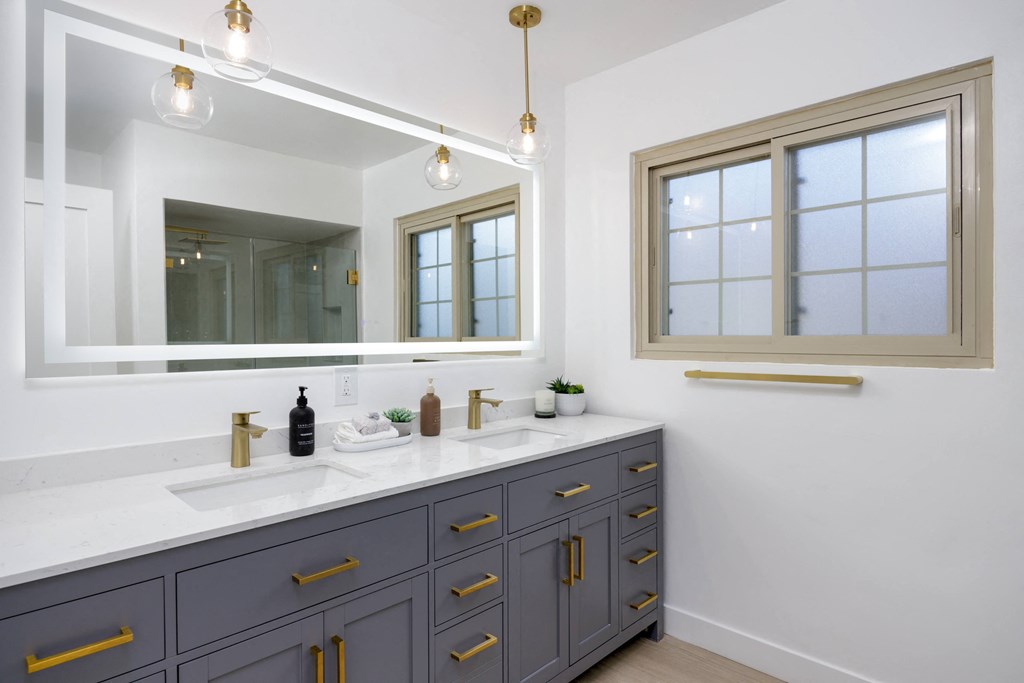 a white bathroom with two sinks and a mirror