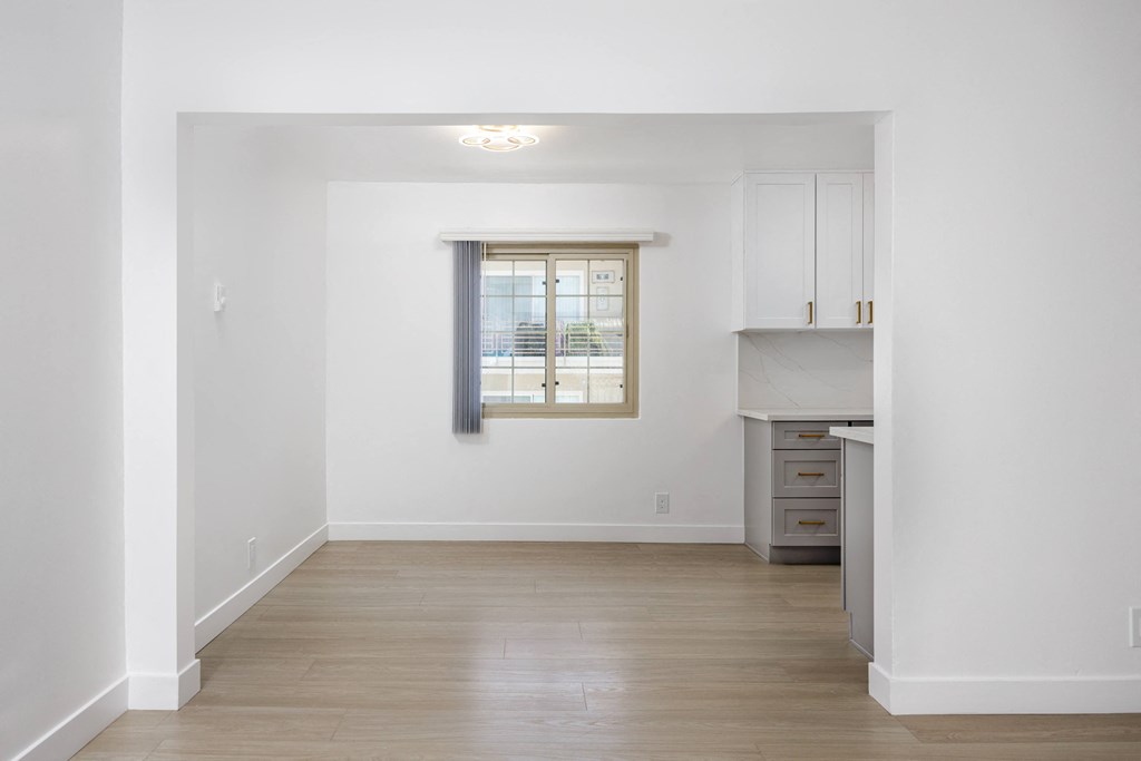 a living room with white walls and a window