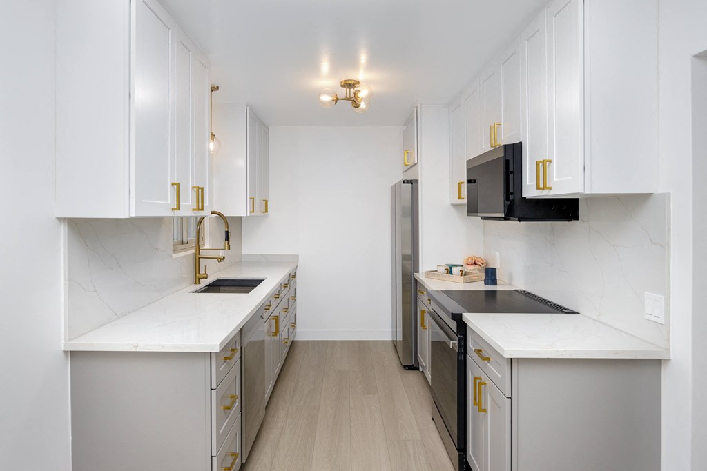 a kitchen with white cabinets and stainless steel appliances