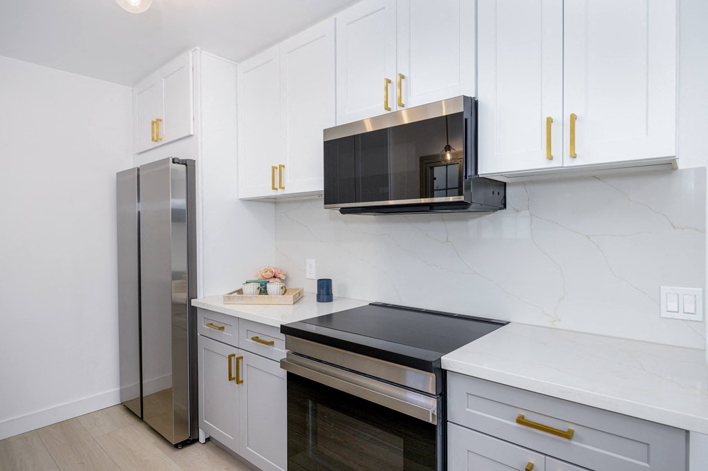 a kitchen with white cabinets and a stainless steel refrigerator