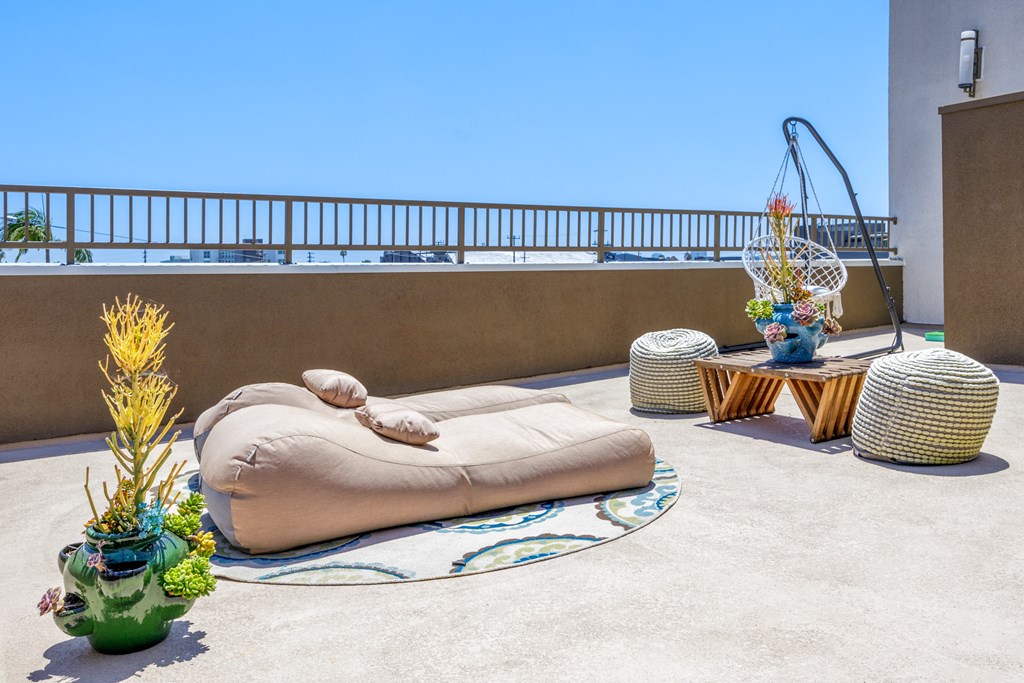 a terrace with a bean bag chair and tables on a roof