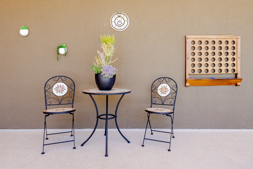 three chairs and a table with a vase of flowers