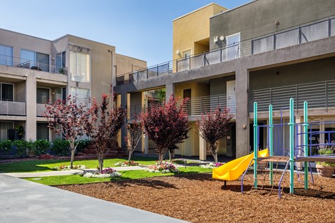 an outdoor playground in front of an apartment building