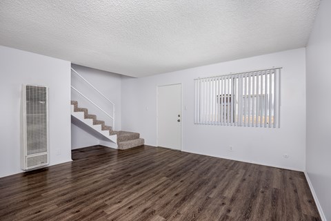 A room with wooden floors and a staircase.