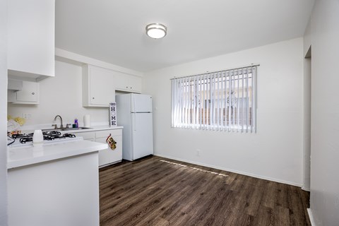 A kitchen with white cabinets and a white counter top.