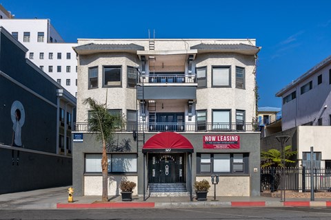 A building with a red awning and a sign that says "Now Leasing".