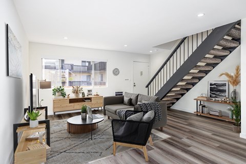 A living room with a staircase and a couch.