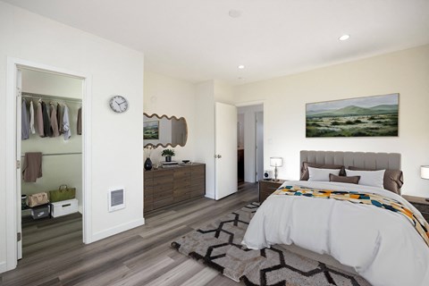 A bedroom with a large bed and a painting on the wall.
