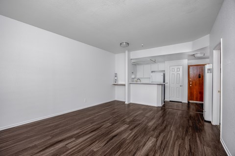 A room with white walls and brown flooring.
