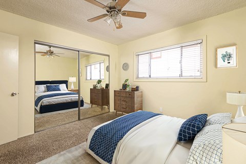 A bedroom with a bed, dresser, and mirror.