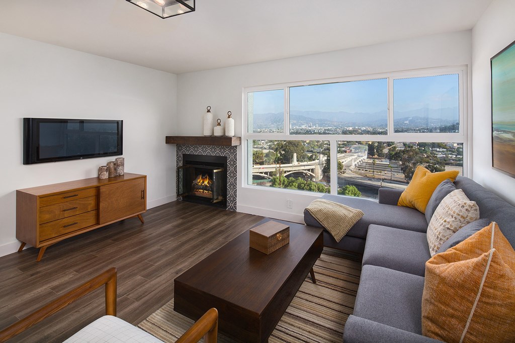 a living room with a couch and a tv and a view of the city
