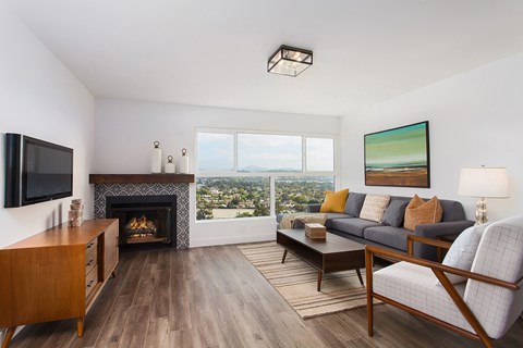 A living room with a fireplace and a painting on the wall.