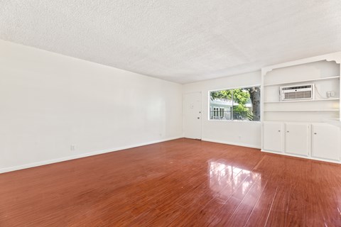Empty room with wooden floor and white walls.