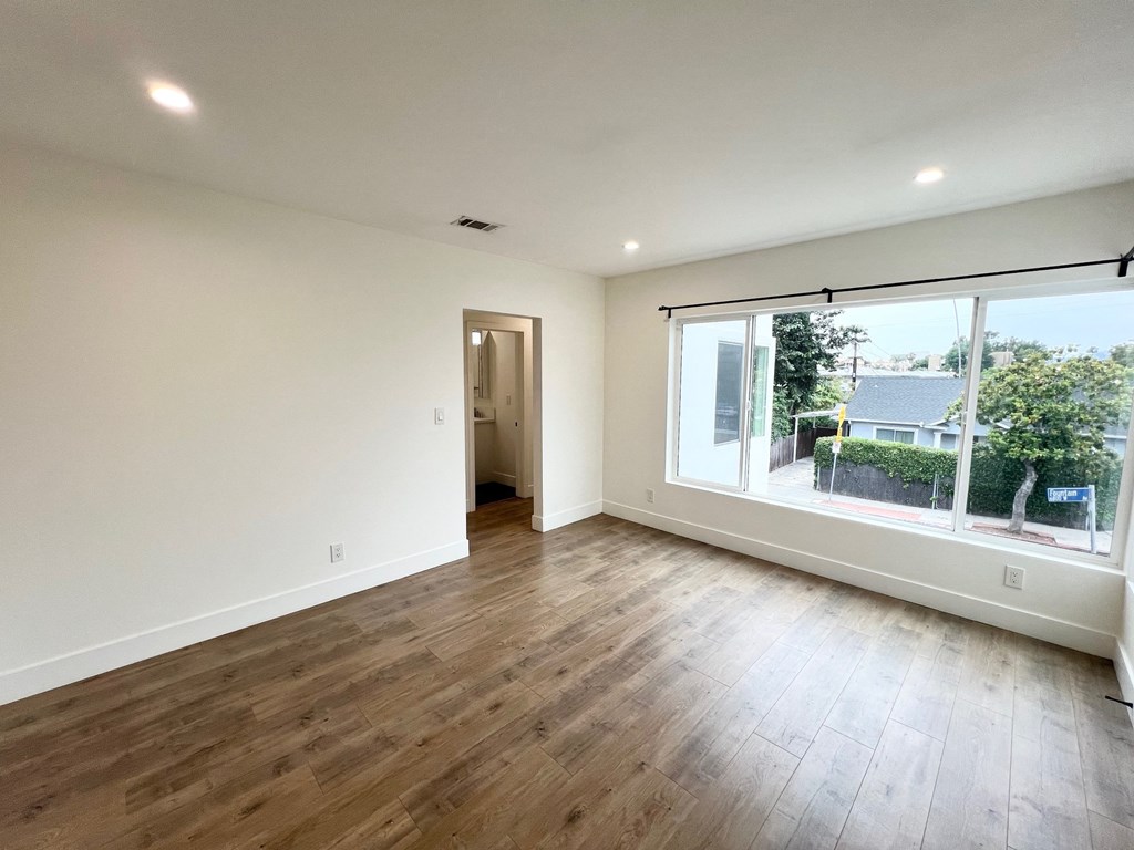 a living room with wood floors and a large window
