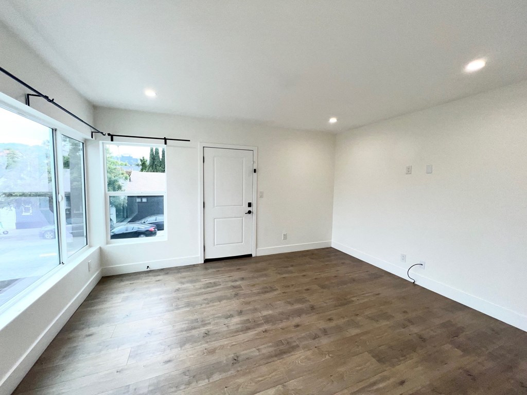 a living room with white walls and a large window