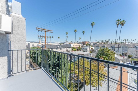 a balcony with a view of the city and palm trees