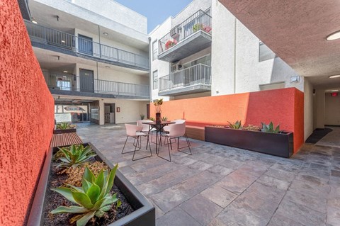 a patio with a table and chairs in a courtyard