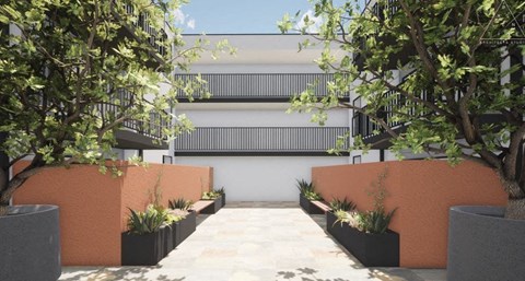 a courtyard with trees and a building in the background