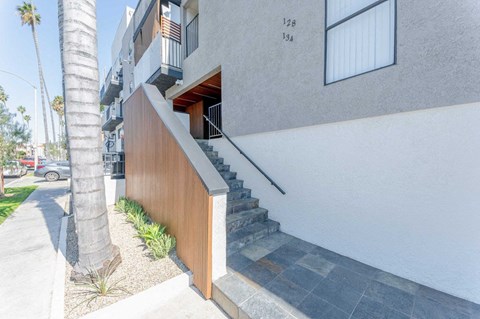 the front of a building with stairs and a sidewalk